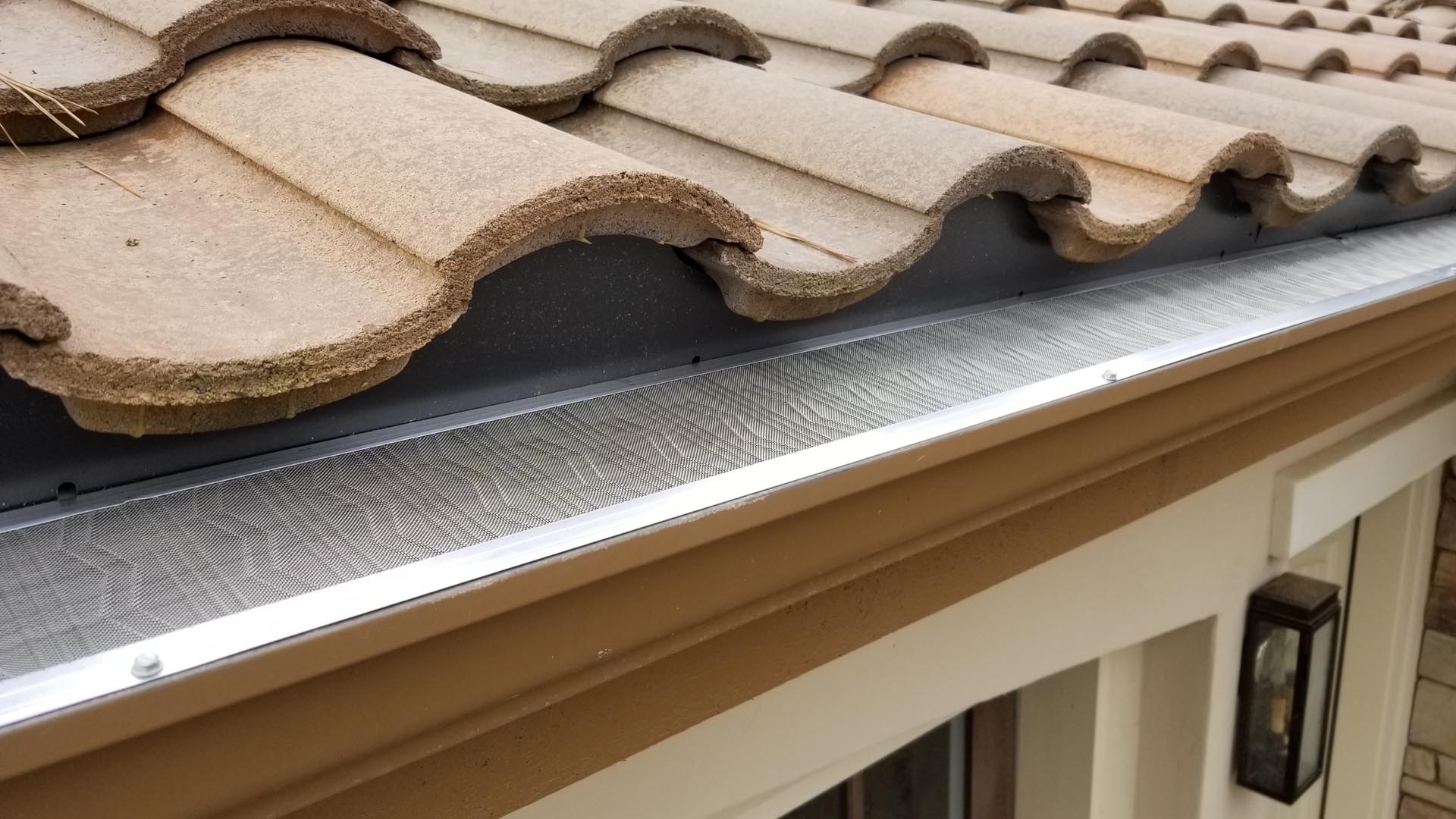 Micro-mesh leaf guard installed on a gutter beneath a Spanish tile roof