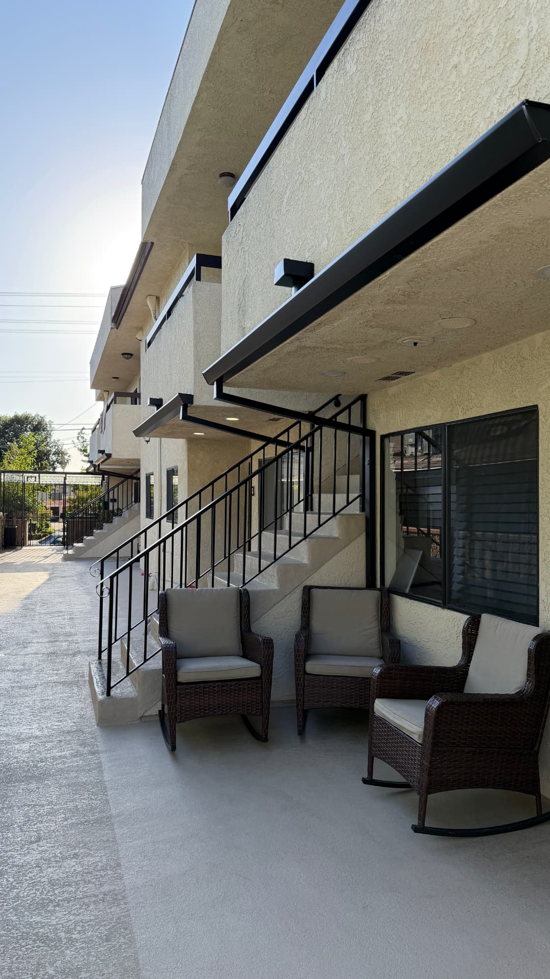Black seamless fascia gutters installed along a Los Angeles apartment building walkway