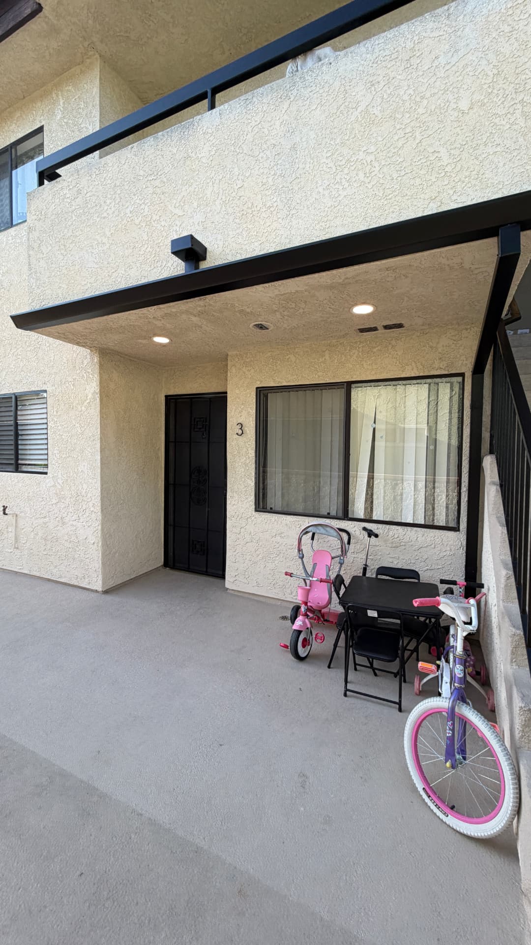 Matte black gutter line and downspout over a ground-floor entry in Los Angeles
