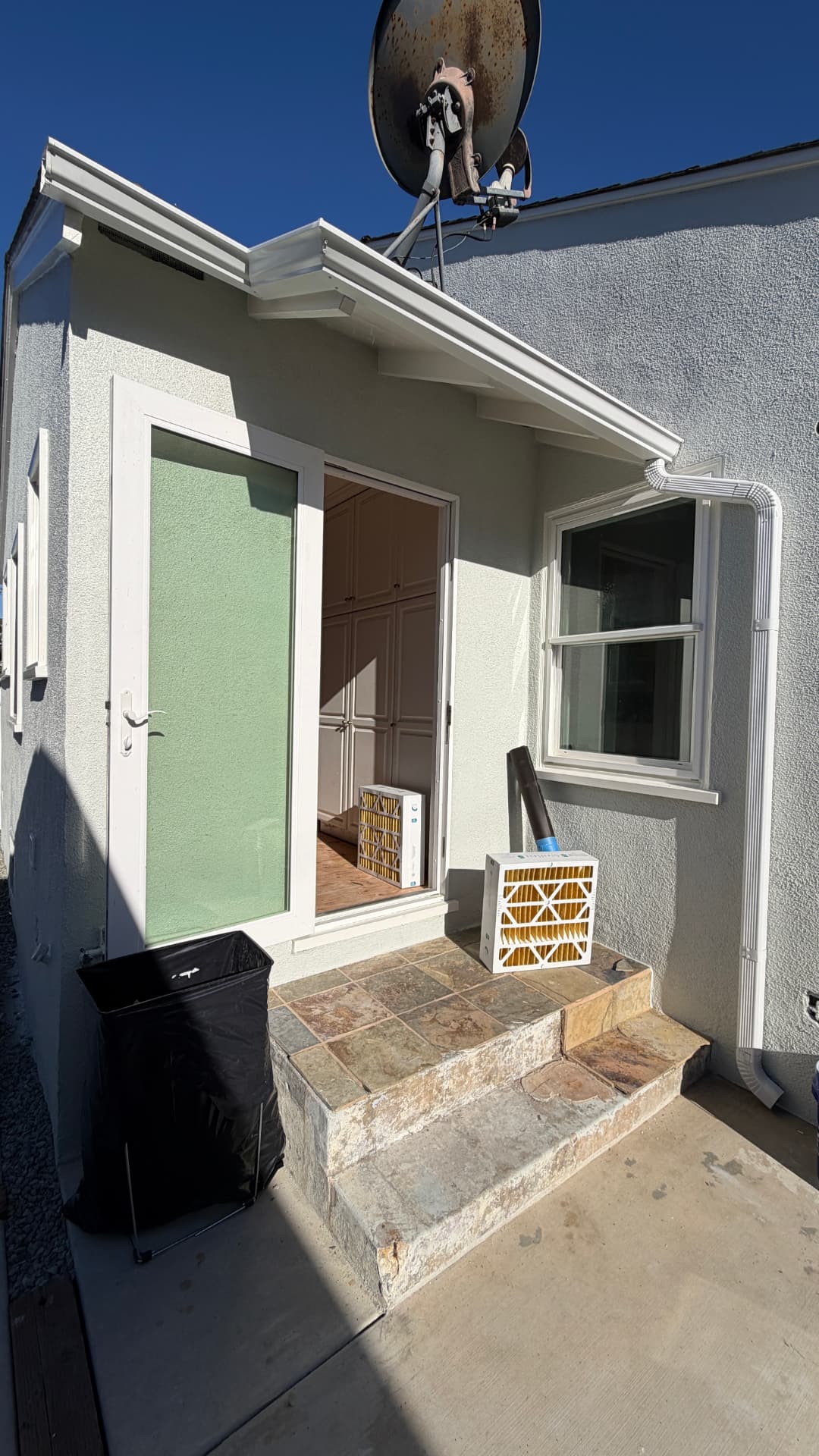 New white seamless rain gutters and downspout on a single-story LA home